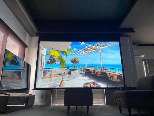 a large screen tv in a room with the ocean on it at casagrande in Koniya