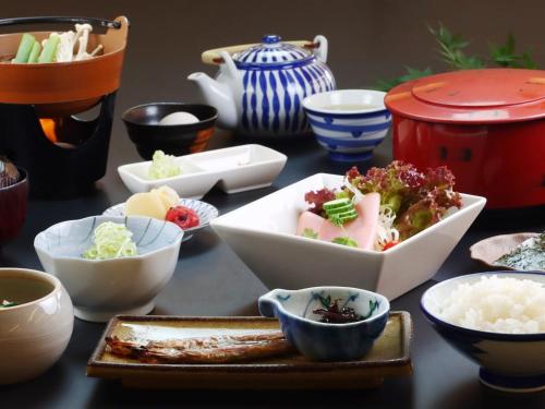 a table topped with bowls and plates of food at Komao in Kiso