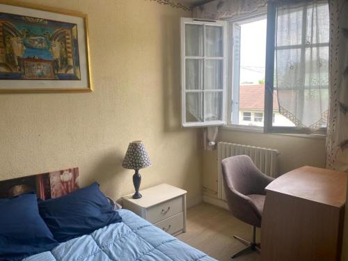- une chambre avec un lit, un bureau et une chaise dans l'établissement villeparis 2 chambres séparées, à Villemoisson-sur-Orge