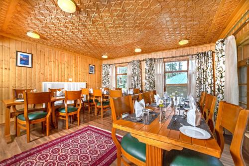 a dining room with a table and chairs in it at Shaw Inn by Stay Pattern in Gulmarg