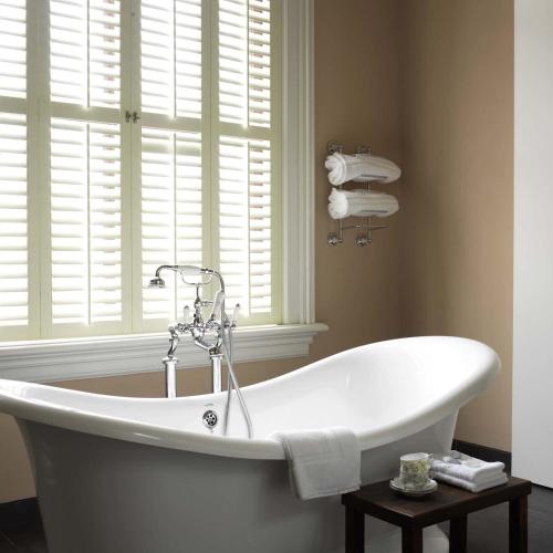 a white bath tub in a bathroom with a window at Suitehotel Pincoffs in Rotterdam