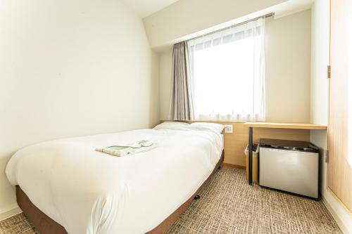 浦安市にあるCVSベイホテルのベッドルーム(大きな白いベッド1台、窓付)
