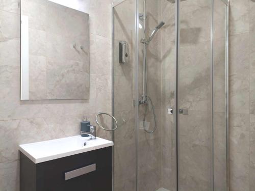 y baño con ducha, lavabo y espejo. en Casa de Huéspedes 12 Octubre Rooms, en Madrid