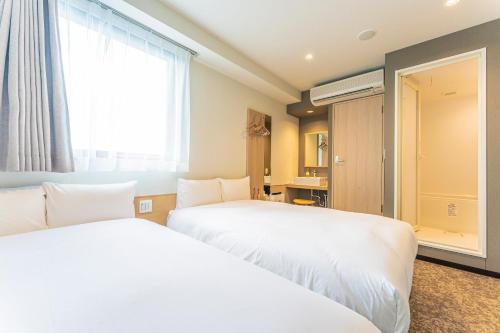 pokój hotelowy z 2 łóżkami i oknem w obiekcie CVS Bay Hotel w mieście Urayasu