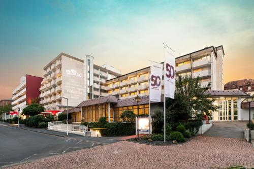 a rendering of a building with flags in front of it at Hotel Frankenland in Bad Kissingen
