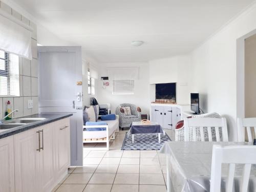 a kitchen and living room with a table and chairs at Pearly Gate in Pearly Beach