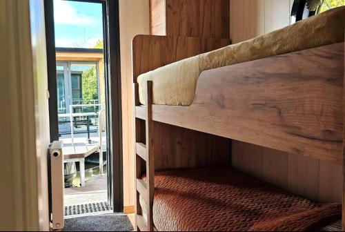 a couple of bunk beds in a room with a porch at Modern, brand new houseboat near Amsterdam in Monnickendam