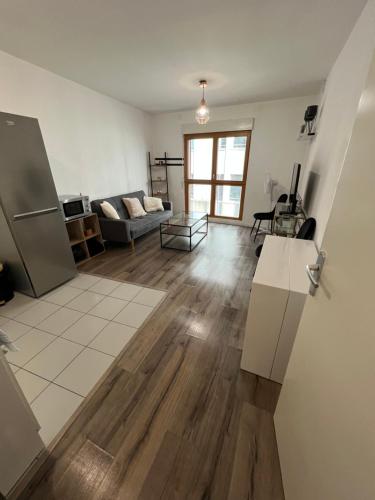 a living room with a couch and a refrigerator at Appartement 2 pièces ligne 1 in Montreuil