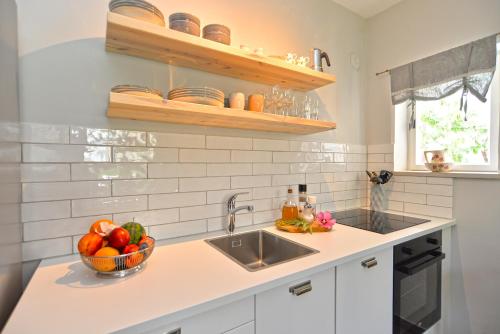 a kitchen with a sink and a bowl of fruit at Apartments Nikola 2113 in Premantura