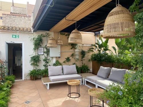 a patio with two couches and a table and chairs at Calendula Hotel in Sant Feliu de Guíxols