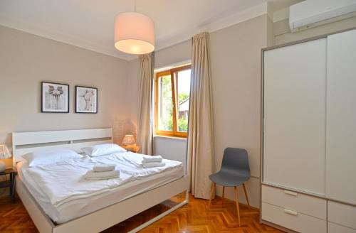 a bedroom with a bed and a chair and a window at Apartments Nikola 2113 in Premantura
