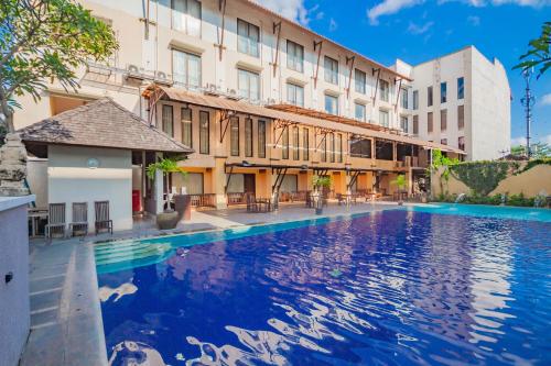 デンパサールにあるGrand Santhi Hotelの建物の前の大きなプール