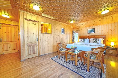 a bedroom with a bed and a table and chairs at Shaw Inn by Stay Pattern in Gulmarg