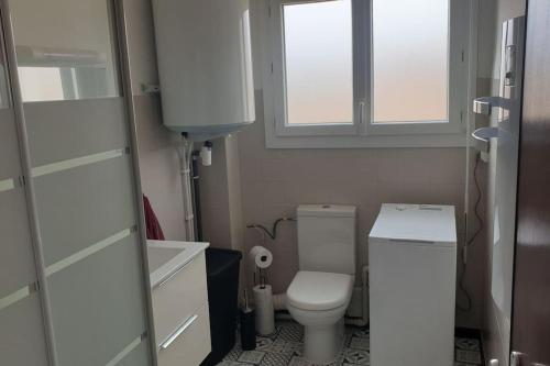 Elle comprend une petite salle de bains pourvue de toilettes et d'une fenêtre. dans l'établissement Appartement 3 pièces, au Boulou