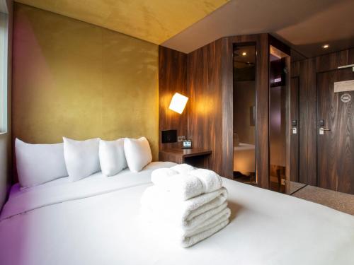 a hotel room with a bed with towels on it at Bloc Hotel London Gatwick Airport in Horley