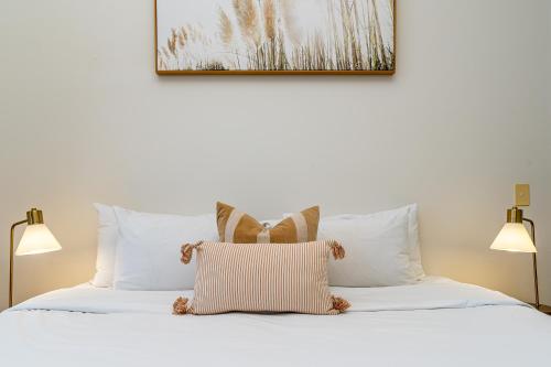 a bed with white pillows and a picture on the wall at AAB Apartments Skyline in Brisbane