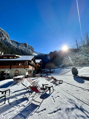 a group of chairs in the snow in front of a building at Hameau des Prodains - Hôtel in Morzine