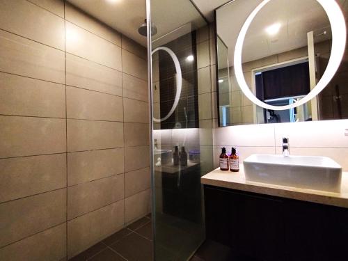 ein Bad mit einem Waschbecken und einem Spiegel in der Unterkunft TopGenting SkyViewSuite4Pax @GrdIonDelmn in Genting Highlands