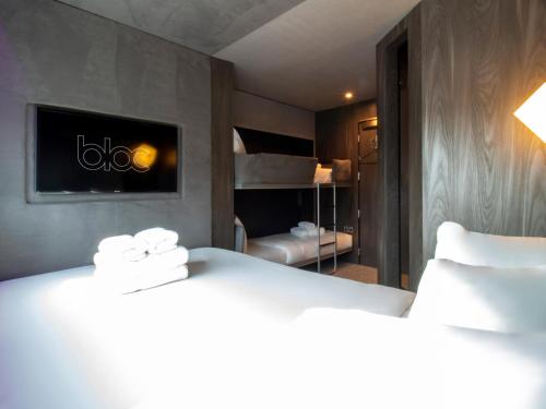 a hotel room with a bed and a television at Bloc Hotel London Gatwick Airport in Horley