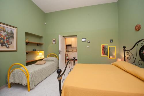 two beds in a room with green walls at B&B Le 4 Stagioni in Nardò