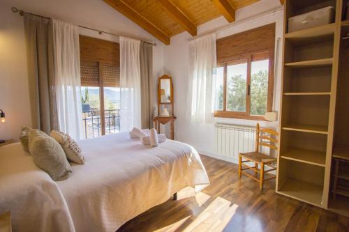 a bedroom with a large white bed and a window at Catalunya Casas Indoor and Outdoor Pools, Sauna, Gym, Games Area in Sant Pau dʼOrdal