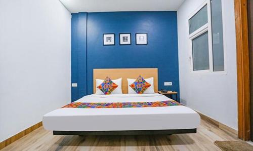 FabHotel F9 Prime Executive Paschim Vihar في نيودلهي: غرفة نوم بسرير كبير بجدار ازرق