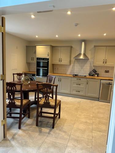 a kitchen with a table and chairs in a room at The Forum-Mountmellick - Coachhouse in Mountmellick