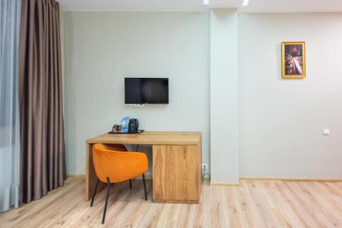 a desk with a chair and a television on a wall at Solo Grand Boshuri Hotel Wellness Resort in Qvemo Boshuri