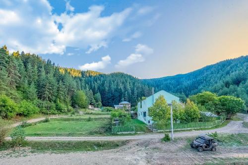 a car parked on a dirt road next to a house at Solo Grand Boshuri Hotel Wellness Resort in Qvemo Boshuri