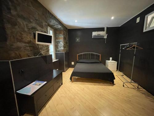 トリエステにあるResidence Noveのベッドルーム1室(ベッド1台、壁にテレビ付)