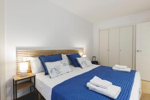 ジローナにあるBravissimo Plaça Catalunya, 2-bedroom apartment with terraceのベッドルーム1室(大型ベッド1台、青と白の枕付)
