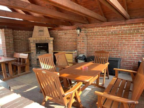 a wooden table and chairs on a patio with a fireplace at Penzión Pri Mlyne in Nitra