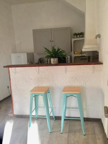 deux tabourets bleus et bruns assis à un comptoir dans l'établissement Appartement Emil centre ville, à Carpentras