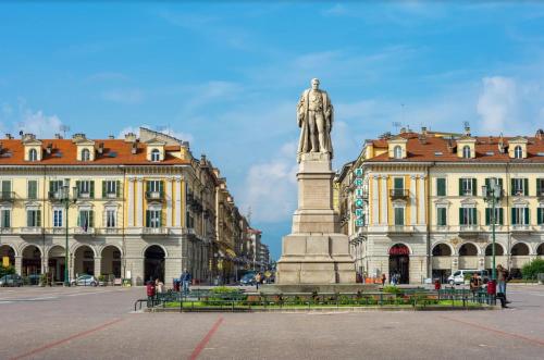 a statue in the middle of a city with buildings at ACERO ROSSO Apartment in Savigliano