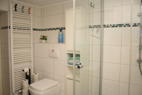 a white bathroom with a shower and a toilet at Your Work & Stay Home in Mechernich in Mechernich
