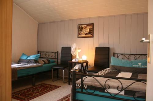 a room with two beds and two chairs in it at Your Work & Stay Home in Mechernich in Mechernich