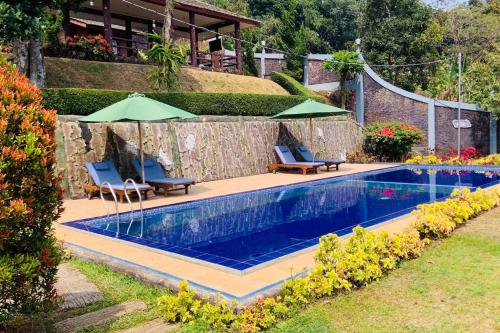einen Pool mit 2 Stühlen und 2 Sonnenschirmen in der Unterkunft Villa Kay Valley in Kopo 2
