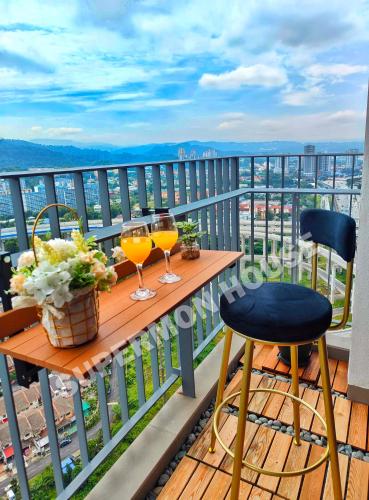 einen Tisch mit zwei Gläsern Wein auf dem Balkon in der Unterkunft Aster Residence, Cheras Luxury Family Suite 3R 3B - Direct MRT Link in Kuala Lumpur