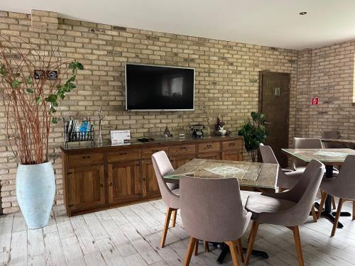 a dining room with a television on a brick wall at Penzión Pri Mlyne in Nitra