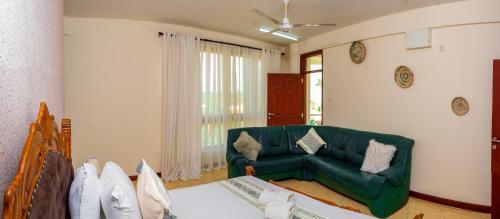 a living room with a green couch and a table at ZaNaKri Homes ;A Great Panorama of Indian Ocean in Mombasa