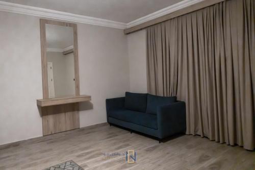 a blue couch in a room with a mirror at فندق جولدن نيو الصفا - Golden New Al Safa Hotel in Jeddah
