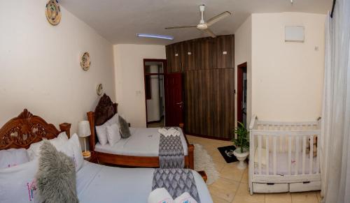 a bedroom with a bed and a crib at ZaNaKri Homes ;A Great Panorama of Indian Ocean in Mombasa