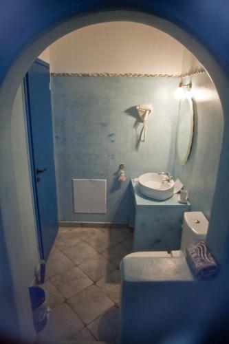 a bathroom with a sink and a kite on the wall at Viva Mare Foinikounta in Finikounta