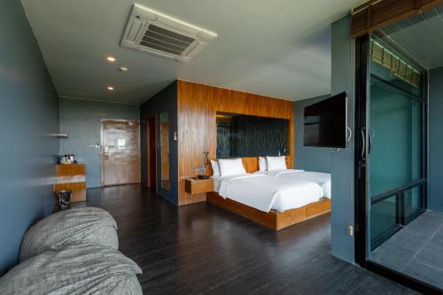 1 dormitorio con 1 cama y TV en The Paz Khao Yai, en Nong Sarai