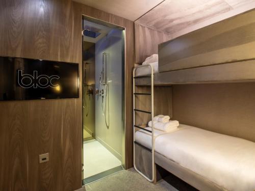a room with two bunk beds and a mirror at Bloc Hotel London Gatwick Airport in Horley