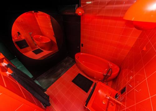 Baño rojo con aseo y lavamanos en Eclipse Red Room, en Bielsko-Biala