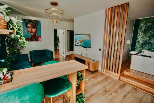 a living room with a table and green chairs at Jacuzzi Apartment in Baia Mare