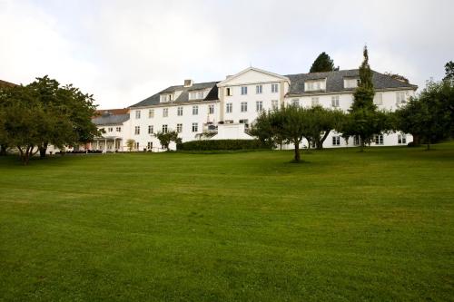 a large white building with a large grass field at Øvre Sem Gård in Asker