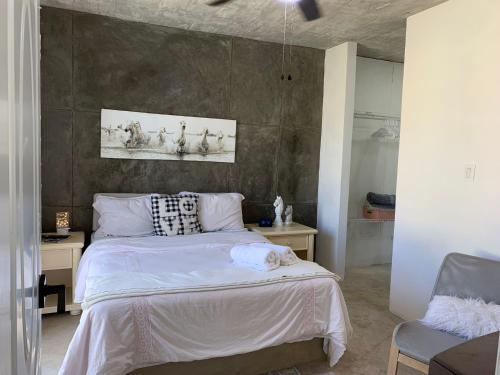 sypialnia z białym łóżkiem ze ścianą w obiekcie VILLA GRANDEZZA w Punta Cana