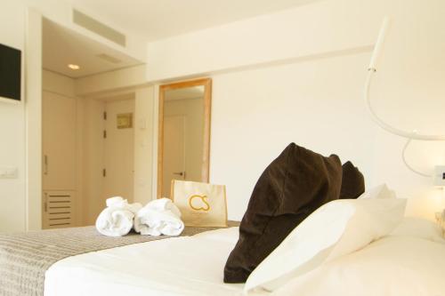 a hotel room with a bed with towels on it at Hotel Cala Saona & Spa in Cala Saona